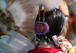 Male Native American wearing full ceremonial dress.