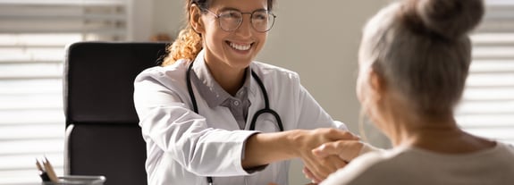Female health care provider shaking hands with her patient.