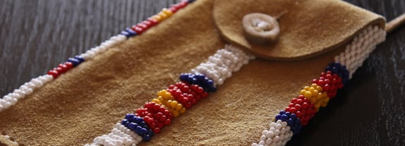 Leather pouch with traditional Native American beadwork accents.