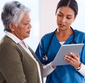 An older woman and a nurse talking at an appointment.