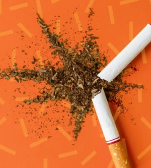Orange textured background with broken cigarette.