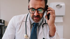 Male health care provider talking on the telephone.